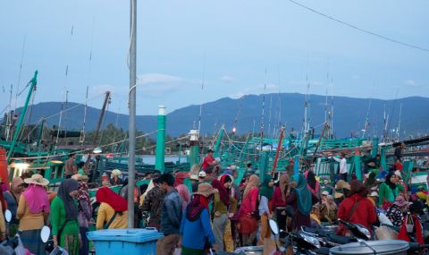 Women selling and buying food at a market in Kampot, Cambodia.